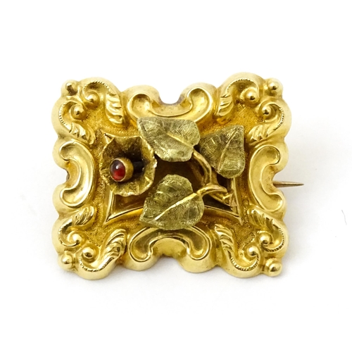 798 - Memorial / mourning jewellery : A 19thC gold brooch with floral and c-scroll detail the flower set w... 