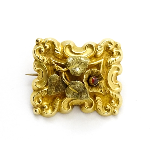 798 - Memorial / mourning jewellery : A 19thC gold brooch with floral and c-scroll detail the flower set w... 