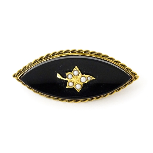 801 - Mourning / memorial jewellery : A 19thC mourning brooch with black onyx set with seed pearl detail, ... 