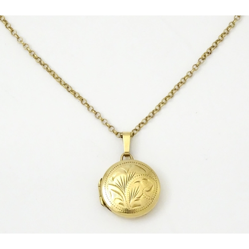 810 - A 9ct gold locket with engraved decoration, on a 9ct gold chain. The whole approx. 17