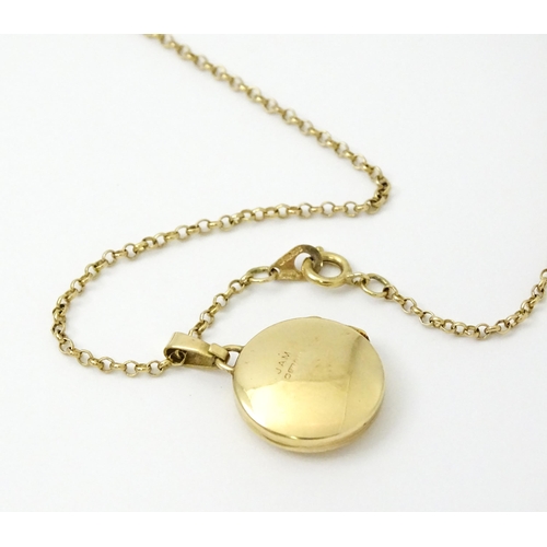 810 - A 9ct gold locket with engraved decoration, on a 9ct gold chain. The whole approx. 17