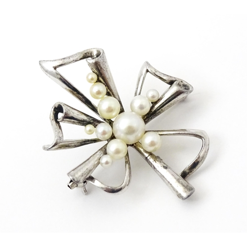 811 - A Mikimoto silver brooch set with pearls and stamped to reverse K Mikimoto Tokyo.. Together with a p... 