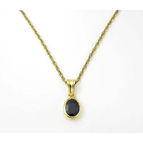 813 - A 9ct gold chain necklace with pendant set with central sapphire. Approx. 21