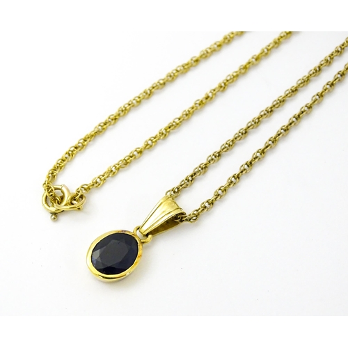 813 - A 9ct gold chain necklace with pendant set with central sapphire. Approx. 21