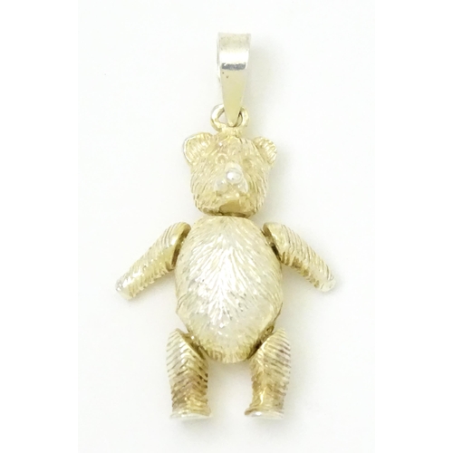 816 - A silver pendant / charm formed as an articulated teddy bear. Approx 1 1/4