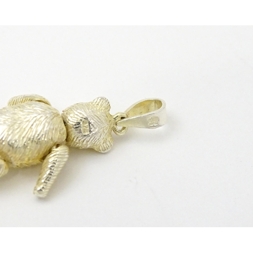 816 - A silver pendant / charm formed as an articulated teddy bear. Approx 1 1/4