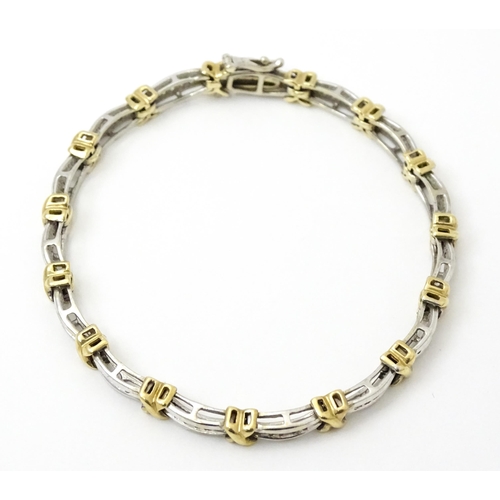 822 - A white metal bracelet marked 10k with yellow metal detail and set with diamonds. Approx 7 1/4