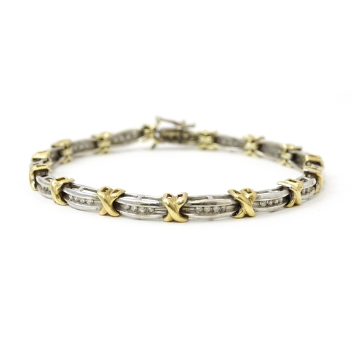 822 - A white metal bracelet marked 10k with yellow metal detail and set with diamonds. Approx 7 1/4