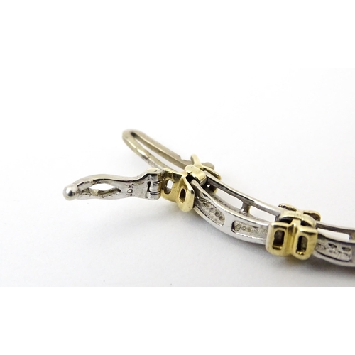 822 - A white metal bracelet marked 10k with yellow metal detail and set with diamonds. Approx 7 1/4