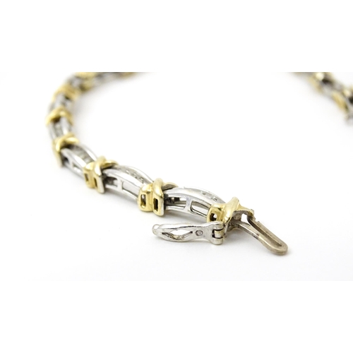 822 - A white metal bracelet marked 10k with yellow metal detail and set with diamonds. Approx 7 1/4