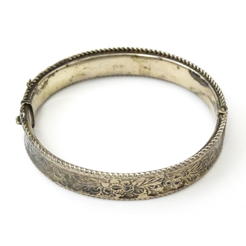 827 - A silver bracelet of bangle form with engraved decoration. Hallmarked Birmingham 1977 with Silver Ju... 