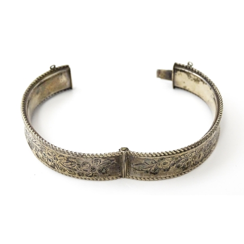 827 - A silver bracelet of bangle form with engraved decoration. Hallmarked Birmingham 1977 with Silver Ju... 