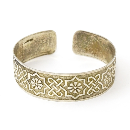 828 - A silver bracelet of cuff bangle form with geometric decoration.  Hallmarked London 1972 LRD.