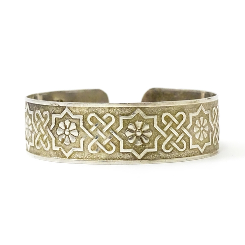 828 - A silver bracelet of cuff bangle form with geometric decoration.  Hallmarked London 1972 LRD.