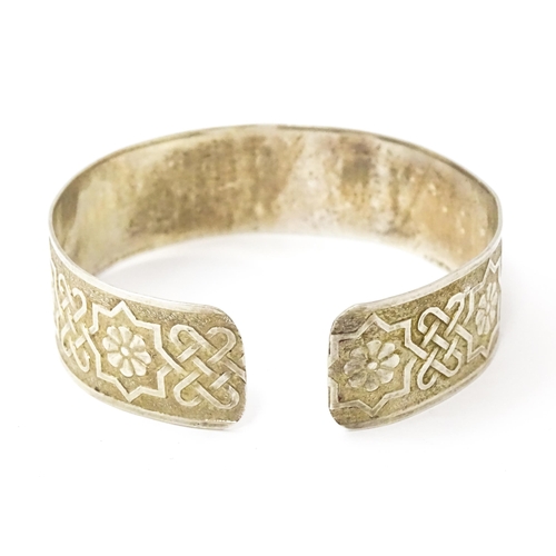 828 - A silver bracelet of cuff bangle form with geometric decoration.  Hallmarked London 1972 LRD.