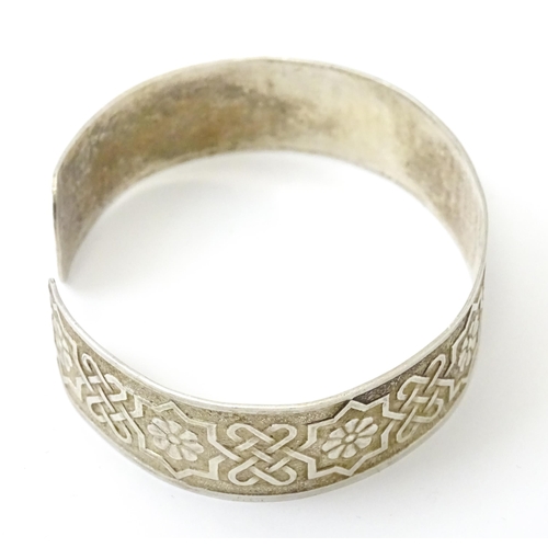 828 - A silver bracelet of cuff bangle form with geometric decoration.  Hallmarked London 1972 LRD.