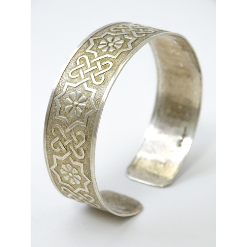 828 - A silver bracelet of cuff bangle form with geometric decoration.  Hallmarked London 1972 LRD.