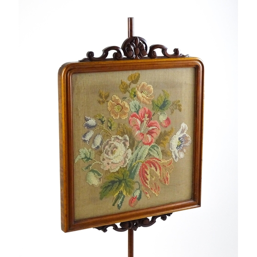 1824 - A late 19thC mahogany pole screen with an embroidered screen surmounted by scrolled carving and rais... 