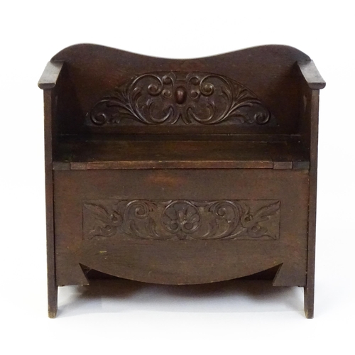 1877 - An early 20thC oak monks bench with pierced heart shaped decoration, having a carved backrest and ap... 