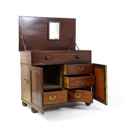 1878 - A Georgian mahogany campaign washstand with a mirror to the interior and sections for internal fitti... 