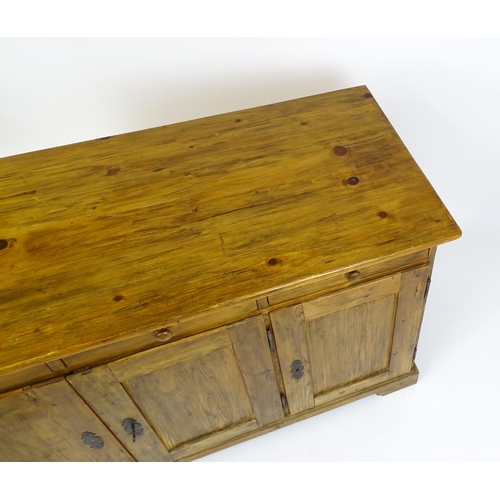 1888 - A 20thC pine sideboard with three short drawers above three panelled cupboard doors raised on bracke... 