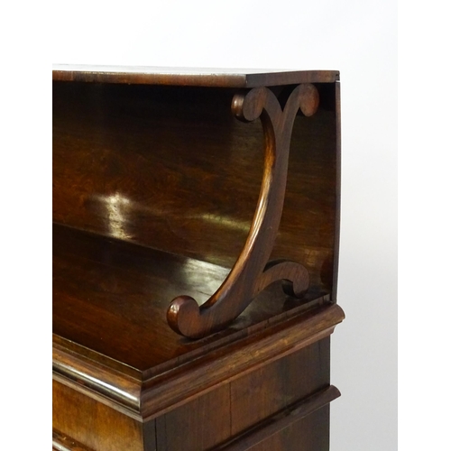 1890 - A 19thC rosewood bookcase with a moulded shelf raised on two scrolled brackets, the base having two ... 