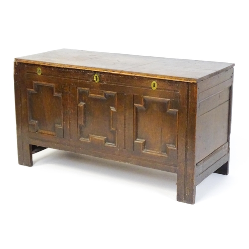 1904 - A late 17thC oak coffer with three geometrically moulded panels raised on stile feet. 48