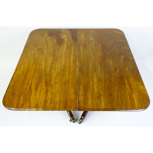 1905 - A 19thC mahogany double pedestal dining table with three additional leaves. The pedestals having tur... 