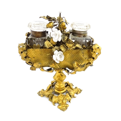 1426 - An unusual French 19thC gilt metal inkstand with scrolling foliate decoration and porcelain flowers,... 