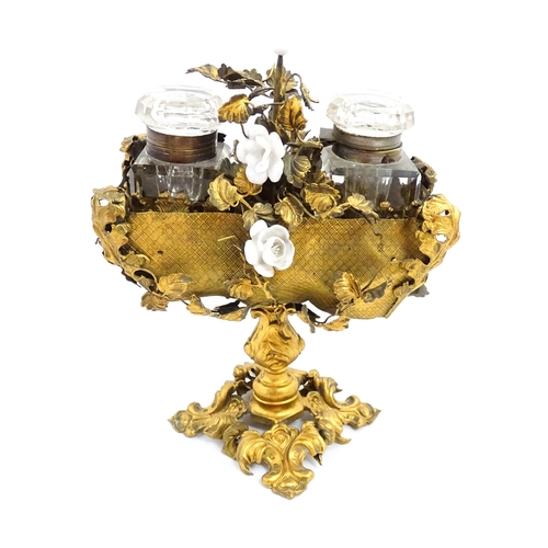 1426 - An unusual French 19thC gilt metal inkstand with scrolling foliate decoration and porcelain flowers,... 