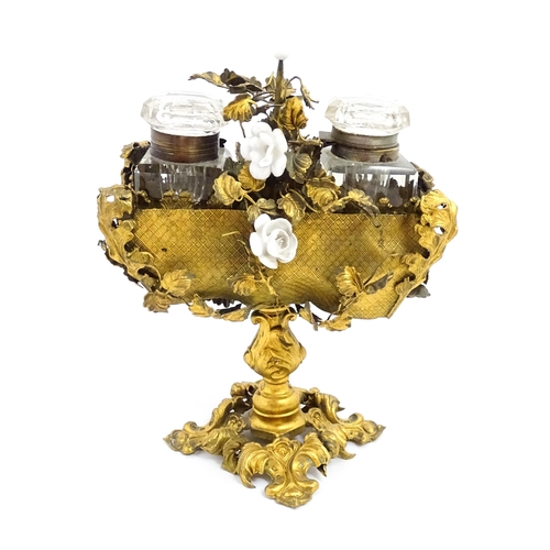 1426 - An unusual French 19thC gilt metal inkstand with scrolling foliate decoration and porcelain flowers,... 