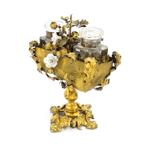 1426 - An unusual French 19thC gilt metal inkstand with scrolling foliate decoration and porcelain flowers,... 