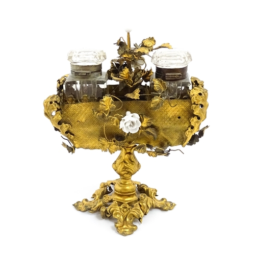 1426 - An unusual French 19thC gilt metal inkstand with scrolling foliate decoration and porcelain flowers,... 