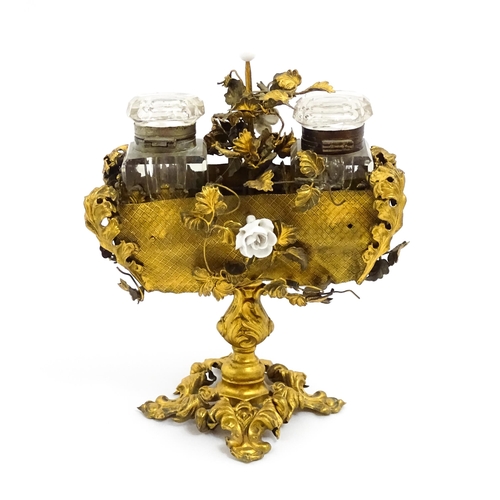 1426 - An unusual French 19thC gilt metal inkstand with scrolling foliate decoration and porcelain flowers,... 