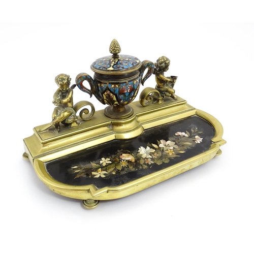 1428 - A French 19thC brass standish / inkstand, the central inkwell of urn form with champleve enamel deco... 