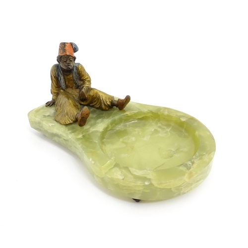 1429 - An early 20thC onyx ashtray surmounted by a cold painted bronze model of a seated Arab boy smoking. ... 