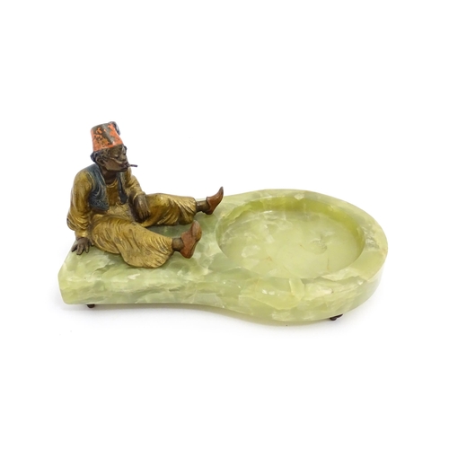 1429 - An early 20thC onyx ashtray surmounted by a cold painted bronze model of a seated Arab boy smoking. ... 