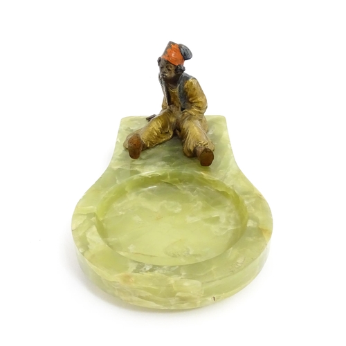 1429 - An early 20thC onyx ashtray surmounted by a cold painted bronze model of a seated Arab boy smoking. ... 