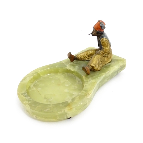 1429 - An early 20thC onyx ashtray surmounted by a cold painted bronze model of a seated Arab boy smoking. ... 