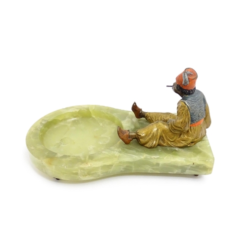 1429 - An early 20thC onyx ashtray surmounted by a cold painted bronze model of a seated Arab boy smoking. ... 