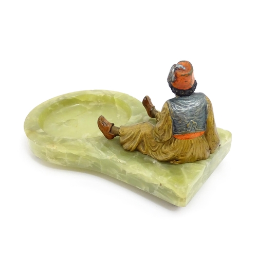 1429 - An early 20thC onyx ashtray surmounted by a cold painted bronze model of a seated Arab boy smoking. ... 