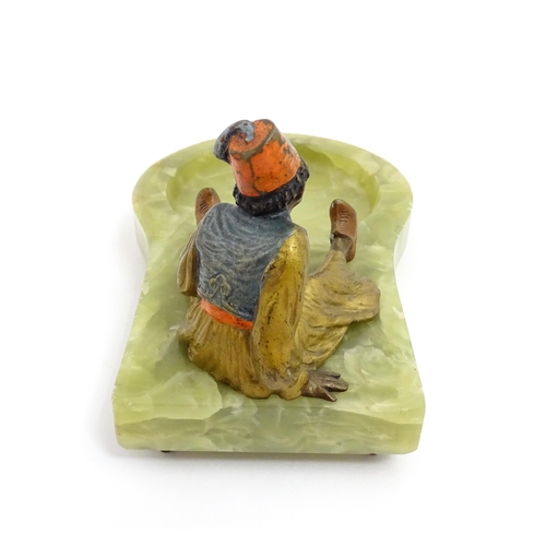 1429 - An early 20thC onyx ashtray surmounted by a cold painted bronze model of a seated Arab boy smoking. ... 