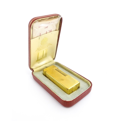 1434 - A cased Dunhill Rollagas pocket lighter, with chequered finish, approx 2 1/2