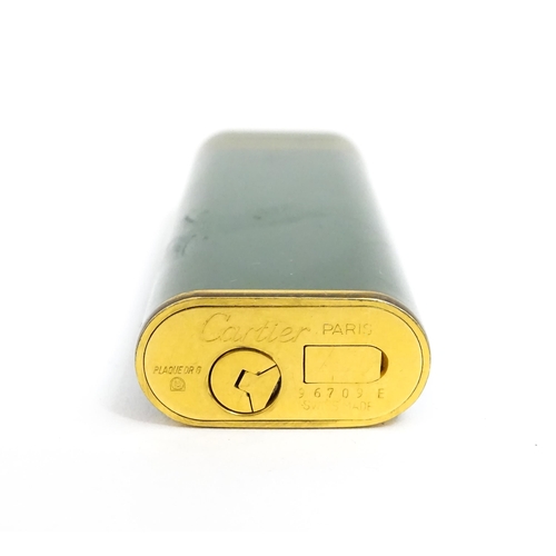 1436 - A Cartier Paris pocket lighter, with gold plated and green enamel finish, serial number 96709E, with... 