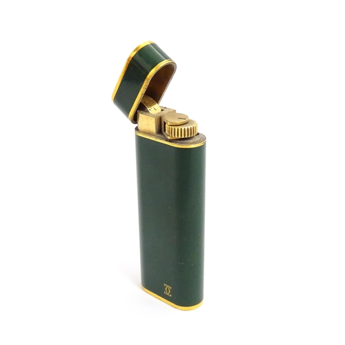 1436 - A Cartier Paris pocket lighter, with gold plated and green enamel finish, serial number 96709E, with... 