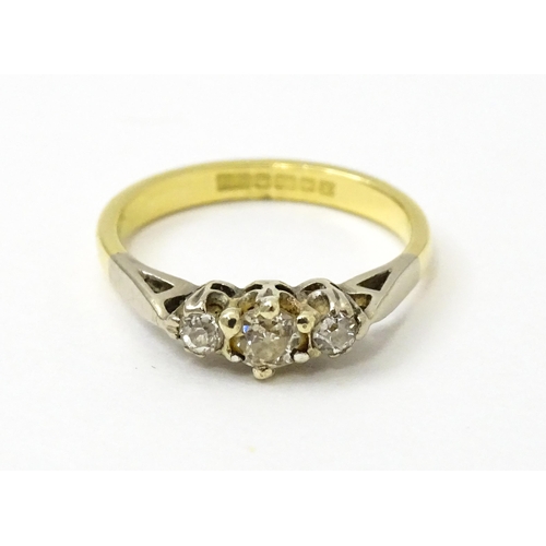 728 - An 18ct ring set with three diamonds. Ring size approx. J 1/2