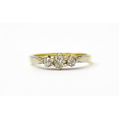 728 - An 18ct ring set with three diamonds. Ring size approx. J 1/2