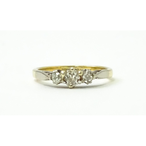 728 - An 18ct ring set with three diamonds. Ring size approx. J 1/2