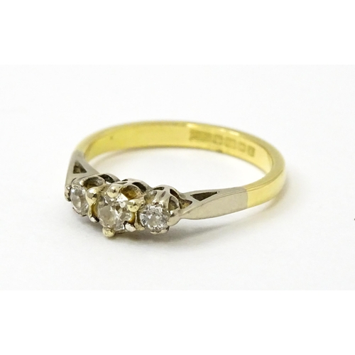 728 - An 18ct ring set with three diamonds. Ring size approx. J 1/2