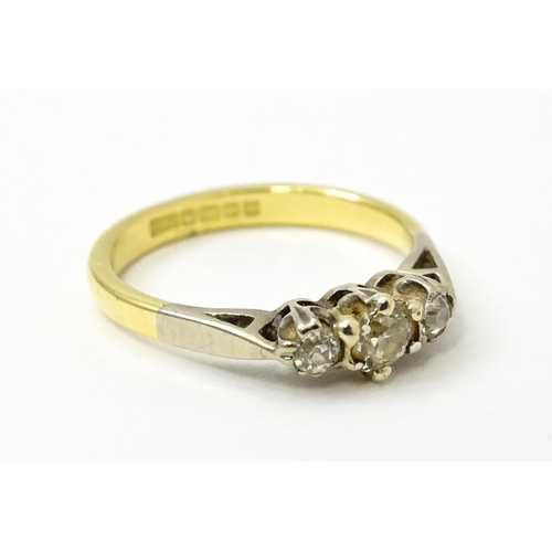 728 - An 18ct ring set with three diamonds. Ring size approx. J 1/2